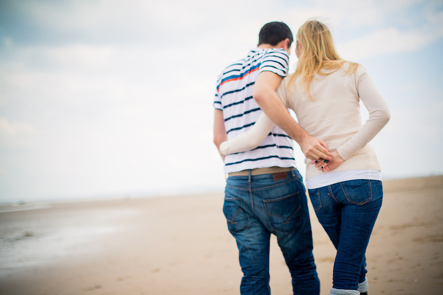 A couple walking along Talacre Beach in their pre wedding photoshoot.