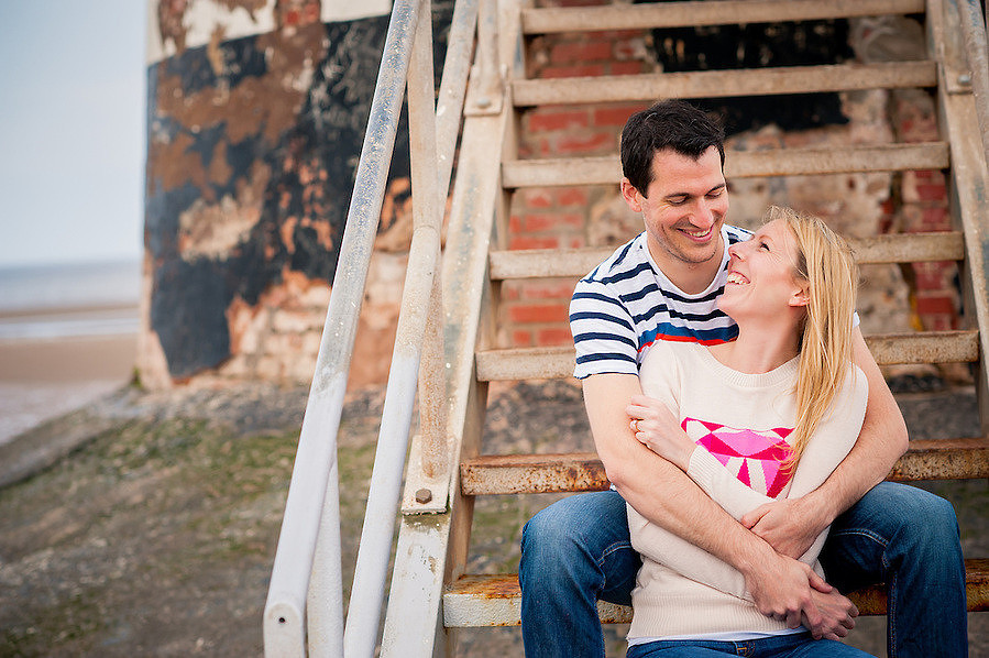 A couple cuddling on Talacre beach during their pre wedding photoshoot.