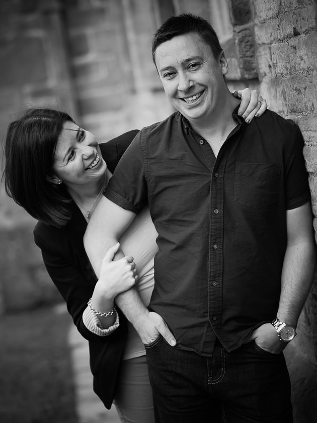 A photograph of Katharine & Matt on their Pre Wedding Shoot at Lyme Park, Cheshire. Photographed by Celynnen Photography, black & white shot of the couple laughing.
