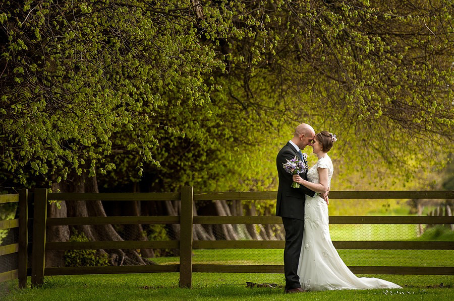 Ross & Mair standing in the grounds of Soughton Hall on their wedding day, photographed by Celynnen Photography.