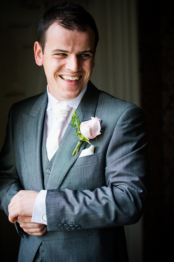 Groom, smiling at his best man at his wedding at Chateaux Rhianfa, Anglesey. Wedding Photographer, Celynnen Photography