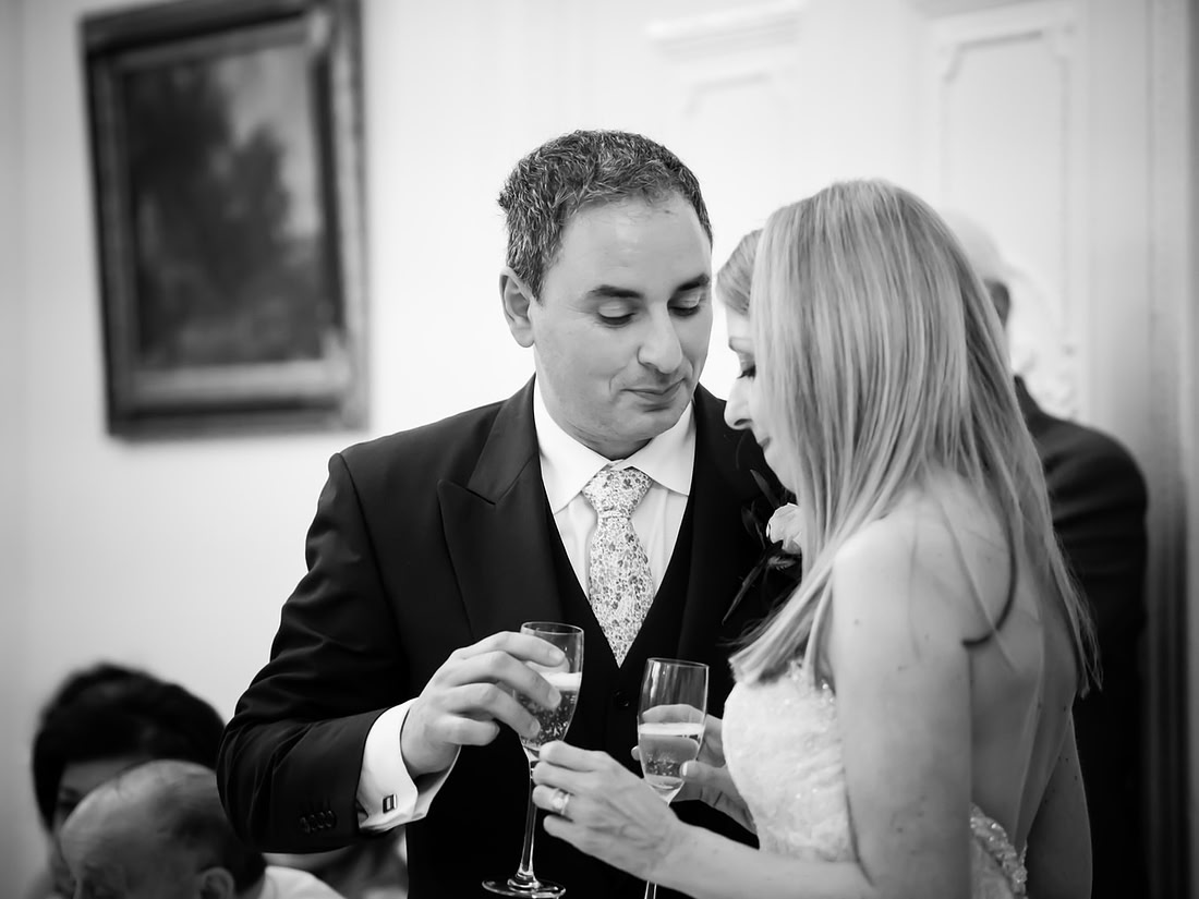Black and white image of the bride and groom during the speeches at a wedding at Taplow House, Buckinghamshire.