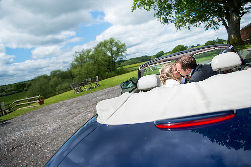 Photo of the bride and groom in a car kissing in Davenham.