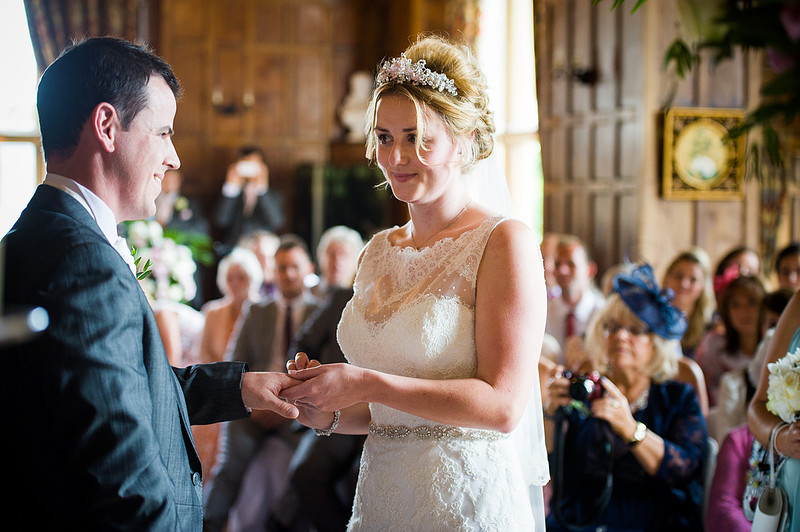 Bride and groom exchanging rings at their wedding at Chateaux Rhianfa, Anglesey. Wedding Photographer, Celynnen Photography