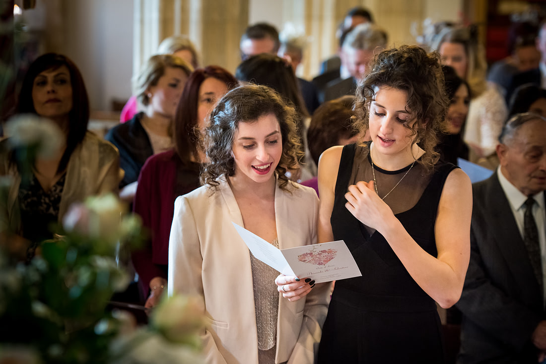 Guests singing during a wedding ceremony in a church in Buckinghamshire