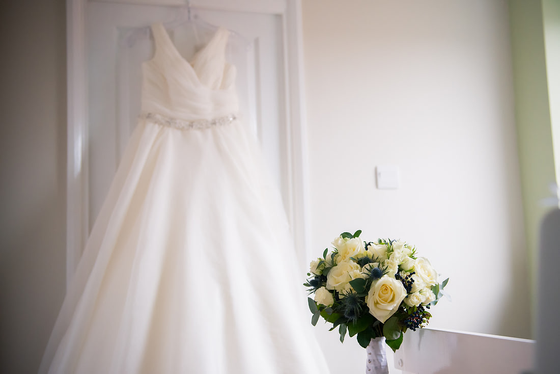 Photo of the bride's wedding dress and bouquet for a wedding at Mere Brook House.