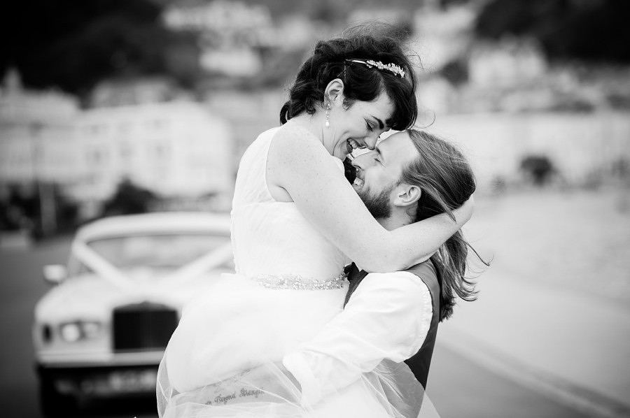 Bride and groom enjoying their wedding day while taking a stroll around Llandudno