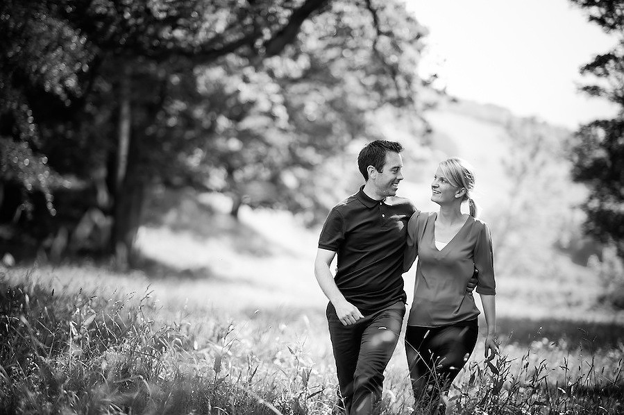 Black and white photo of an engaged couple walking during their pre-Wedding portrait session with Celynnen Photography at the beautiful Crogen Estate