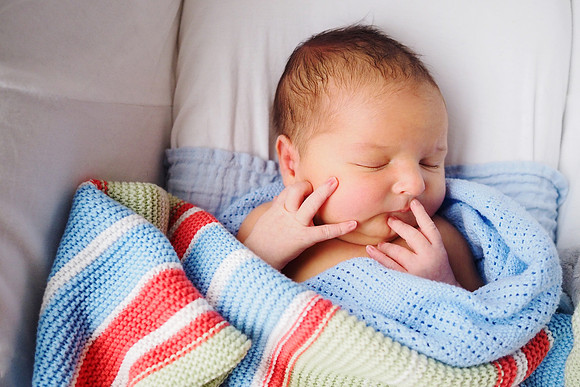 Newborn baby having a sleep during a bump to baby photoshoot in North Wales
