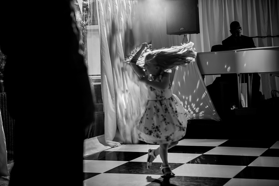 Black & White photograph of a young wedding guest dancing at the wedding reception at Soughton Hall.