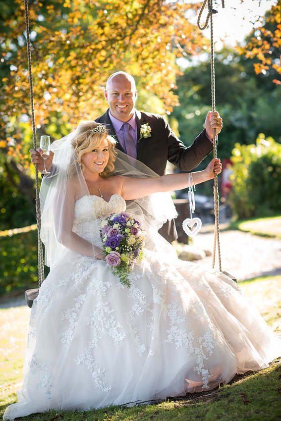 Portrait of the bride and groom on a swing at Chateau Rhianfa.