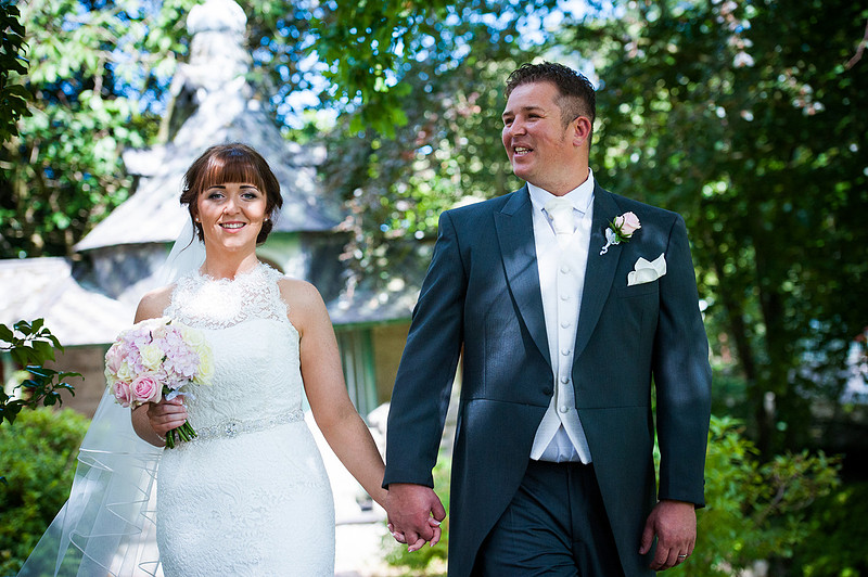 bride and groom walking in the garden at their wedding in Chateaux Rhianfa, Anglesey. Wedding Photographer, Celynnen Photography