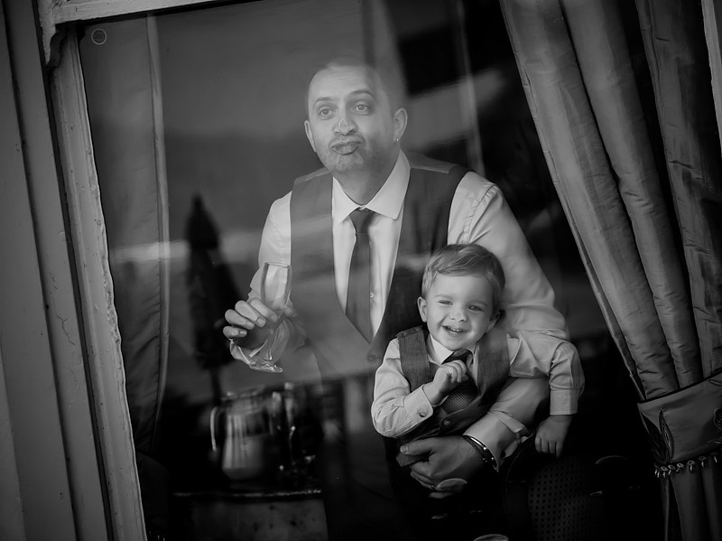 Wedding photography in Cheshire. Father and son having fun in the window.