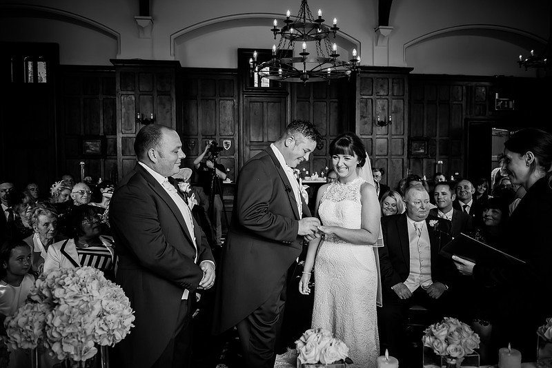 Black and white image of exchanging the rings in a wedding in Chateaux Rhianfa, Anglesey. Wedding Photographer, Celynnen Photography