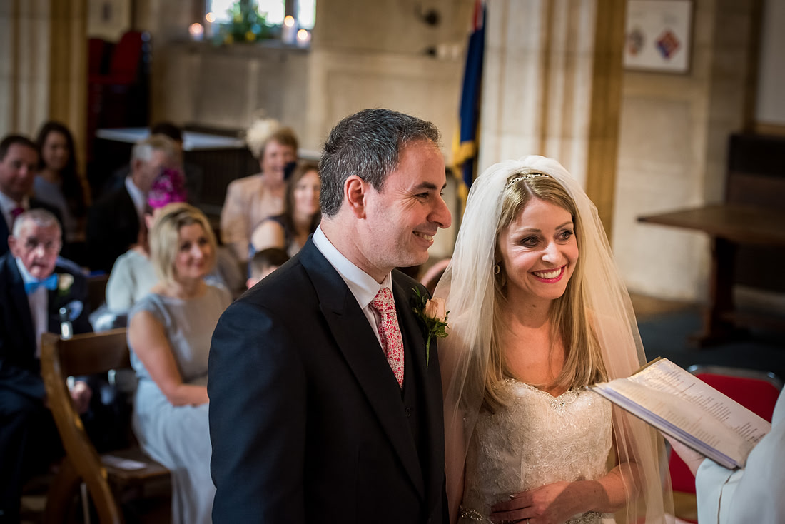 Image of the bride and groom looking happy during their wedding ceremony in Buckinghamshire.