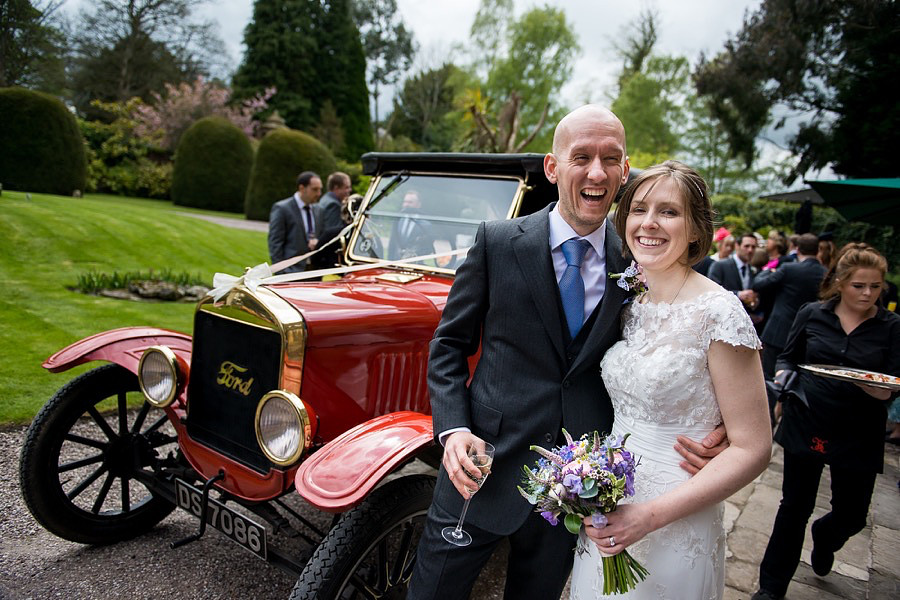 A photograph of Mair & Rose pictured in front of the wedding car after they have arrived at Soughton Hall.