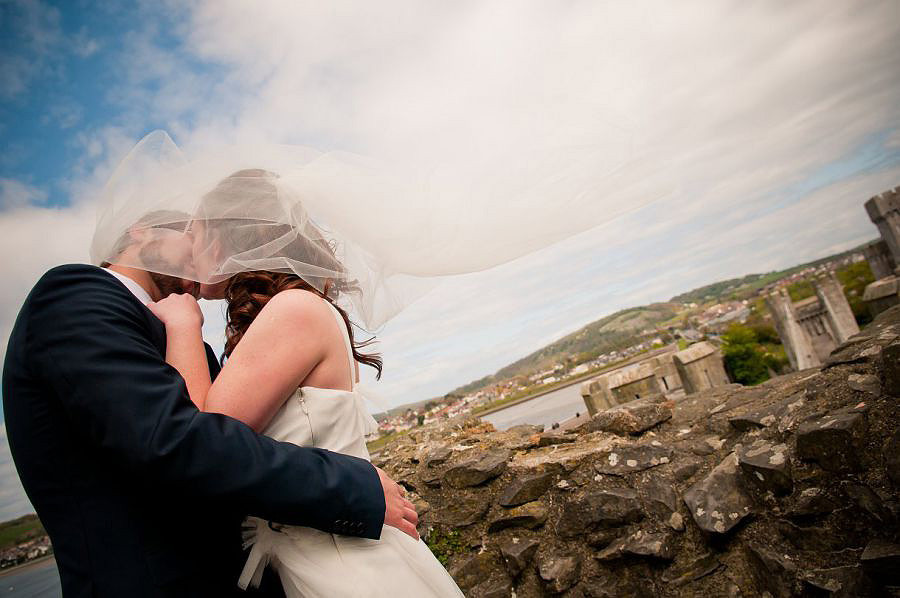 Bride and Groom kissing over Conwy Bay. Wedding Photography Conwy Castle