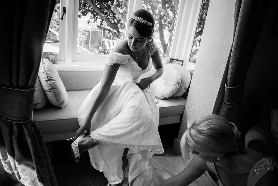 Wedding photographer Ruthin Celynnen Photography, bride putting her shoes on