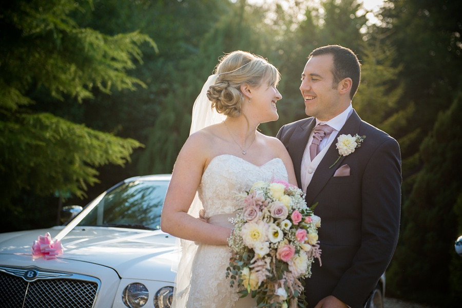 Bride and Groom Smiling Together by Wedding Car by North Wales Wedding Photographer Celynnen Photography