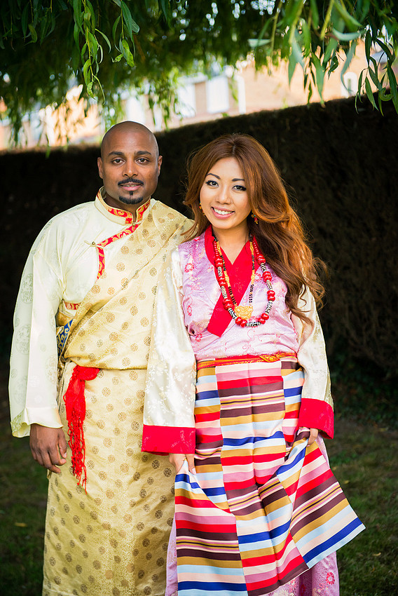 The bride and groom in their traditional tibetan buddhist wedding ceremony dresses after their lion quays wedding in Oswestry