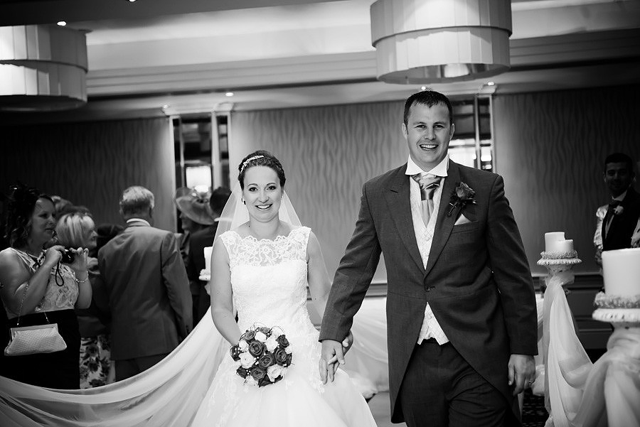 Black and white image of the bride and groom leaving the wedding ceremony as a married couple at Grosvenor Pulford
