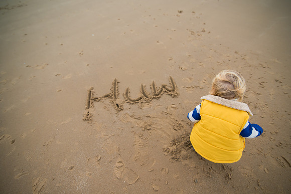 A little boy having fun on a day out to Deganwy Beach in North Wales on a portrait photoshoot