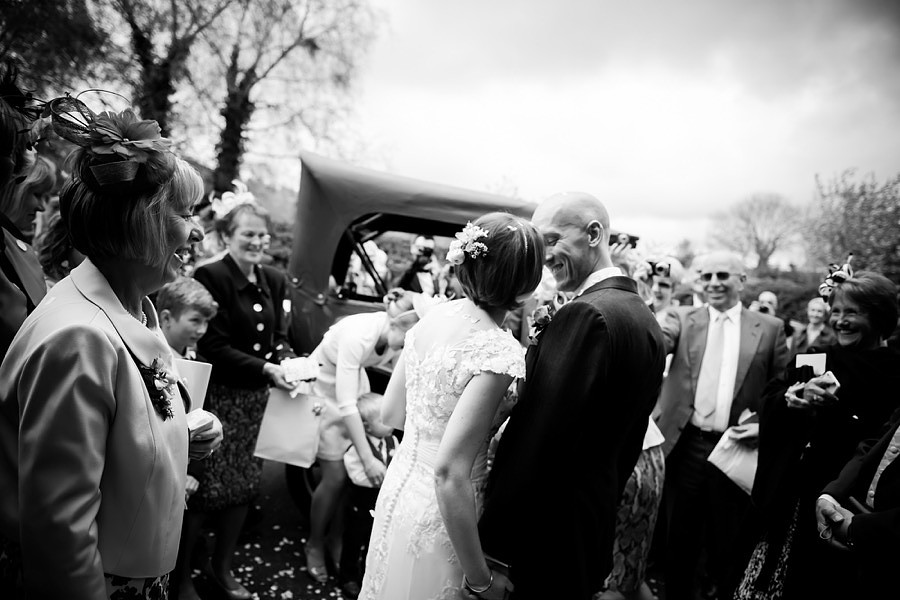 A black & white photograph of Mair & Ross after the church service and before they leave for the wedding reception.