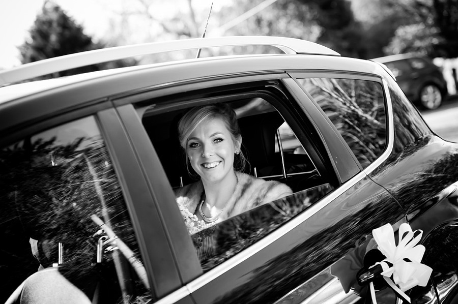 Bride smiling in wedding car by North Wales Wedding Photographer Celynnen Photography