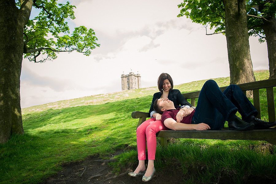 Photograph of Katharine & Matt looking relaxed sitting on a bench at Lyme Park, photographed by Celynnen Photography.