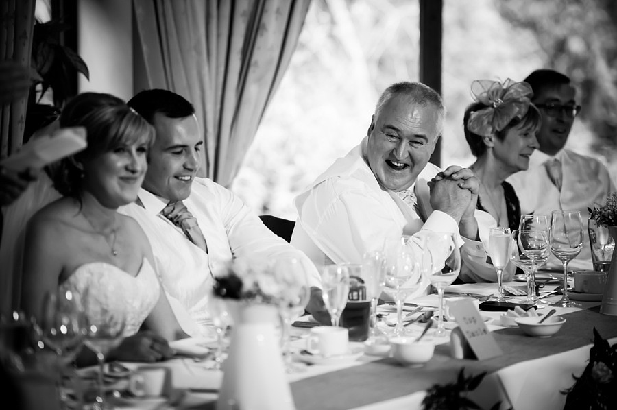Bride, Groom and Others Smiling at Wedding Reception by North Wales Wedding Photographer Celynnen Photography