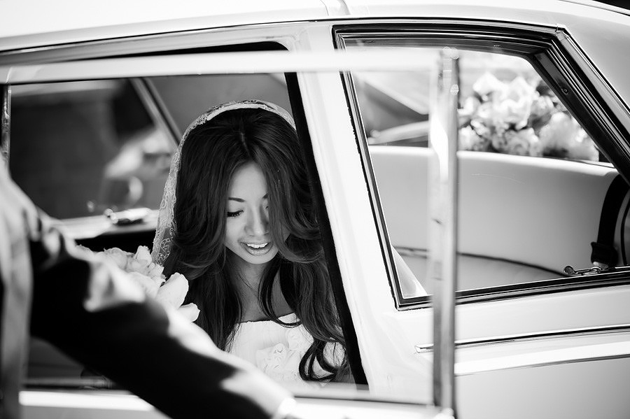 bride walking out of her wedding car to go to her church wedding ceremony before the wedding reception at the lion quays in oswestry, shropshire.