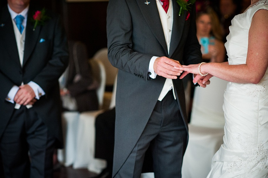 Groom putting ring on Bride at a wedding in Portmeirion.