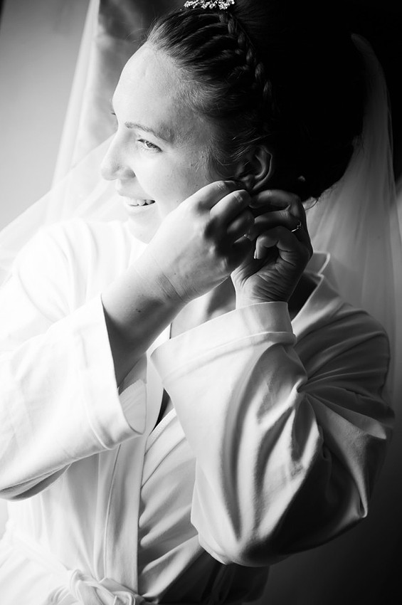 Bride putting her earrings and jewellery on during bridal preparation at the Grosvenor Pulford