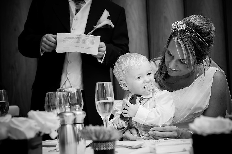Little boy sitting on the bride's knee during the speeches at a wedding in Portmeirion.