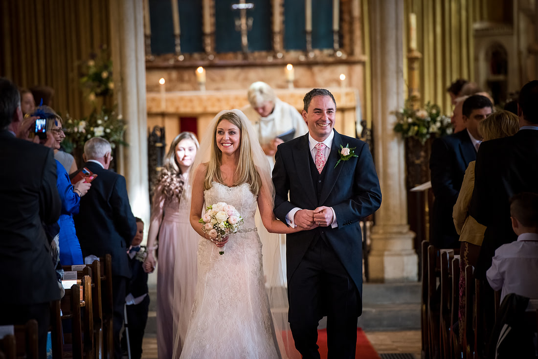 Image of the bride and groom leaving their wedding ceremony as husband and wife, in Buckinghamshire.