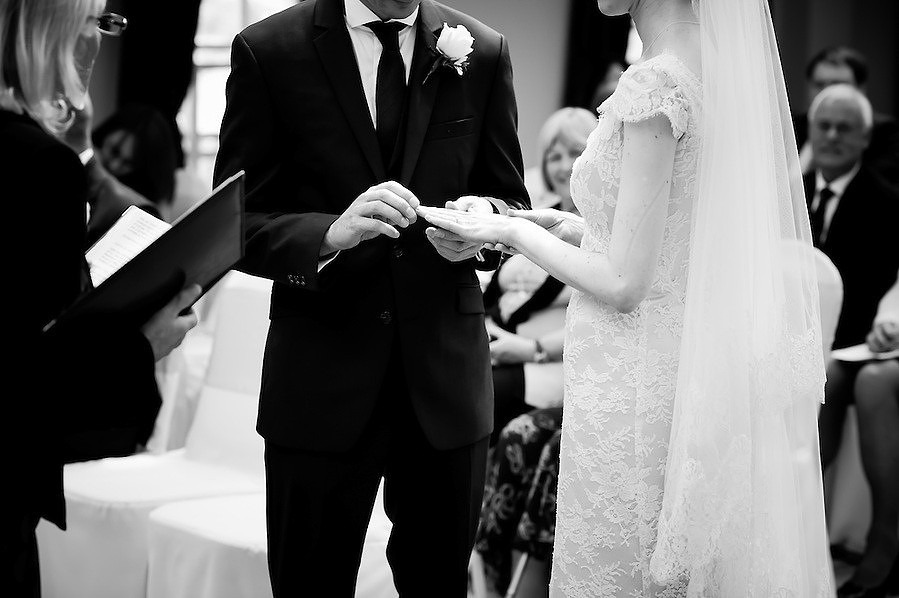 Black and white image of the exchanging of the rings at a wedding at Plas Hafod.