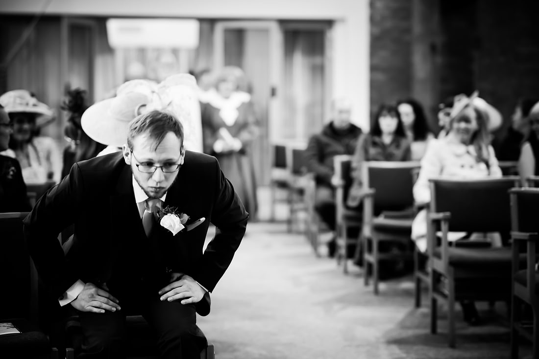 Black and white image of the groom preparing himself for the wedding ceremony.
