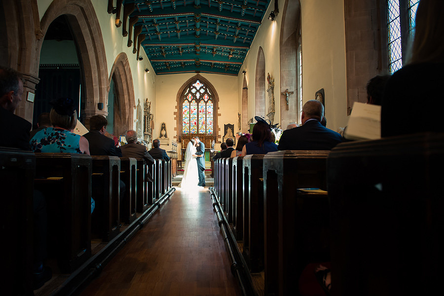 Wedding photographer Ruthin Celynnen Photography, bride and groom kissing in church