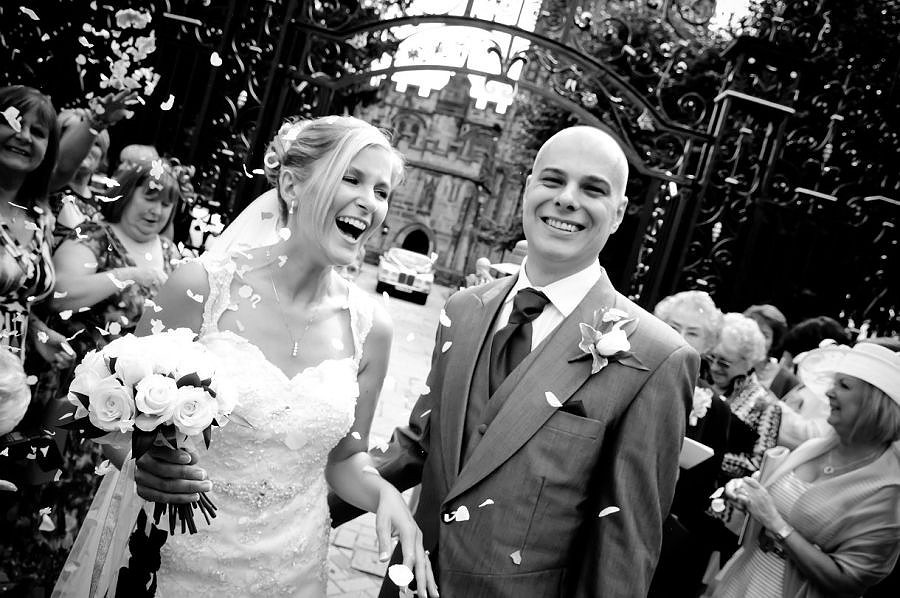 the bride and groom under confetti at the st-giles church, wrexham after their wedding