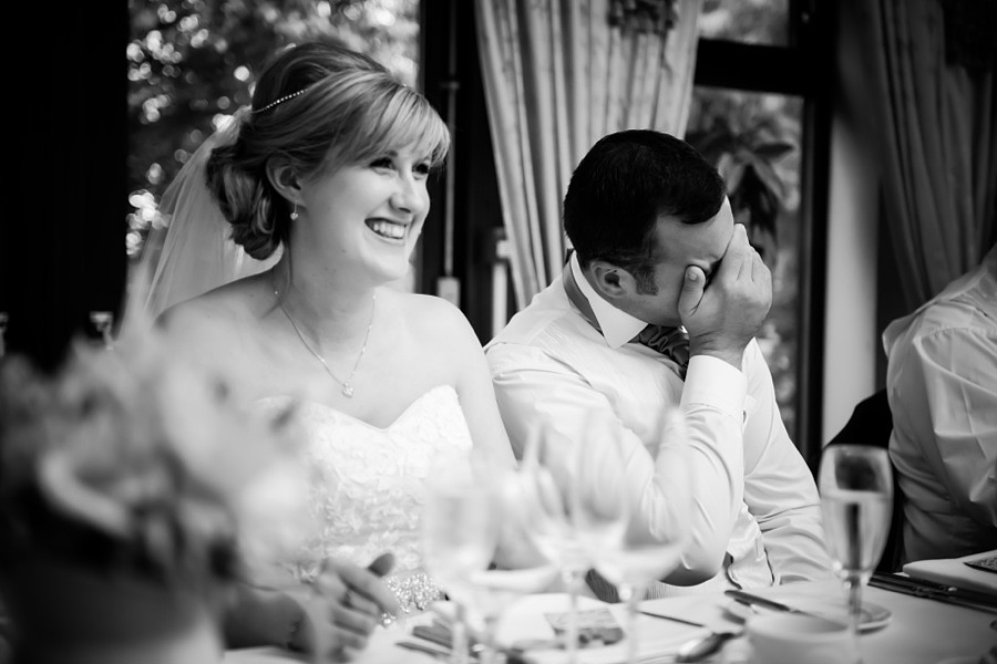 Bride and Groom Laughing at Speeches by North Wales Wedding Photographer Celynnen Photography
