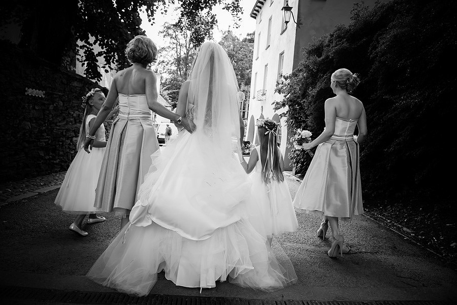 Bride being accompanied to the Hercules Hall for her wedding in Portmeirion by her bridesmaids and flower girls