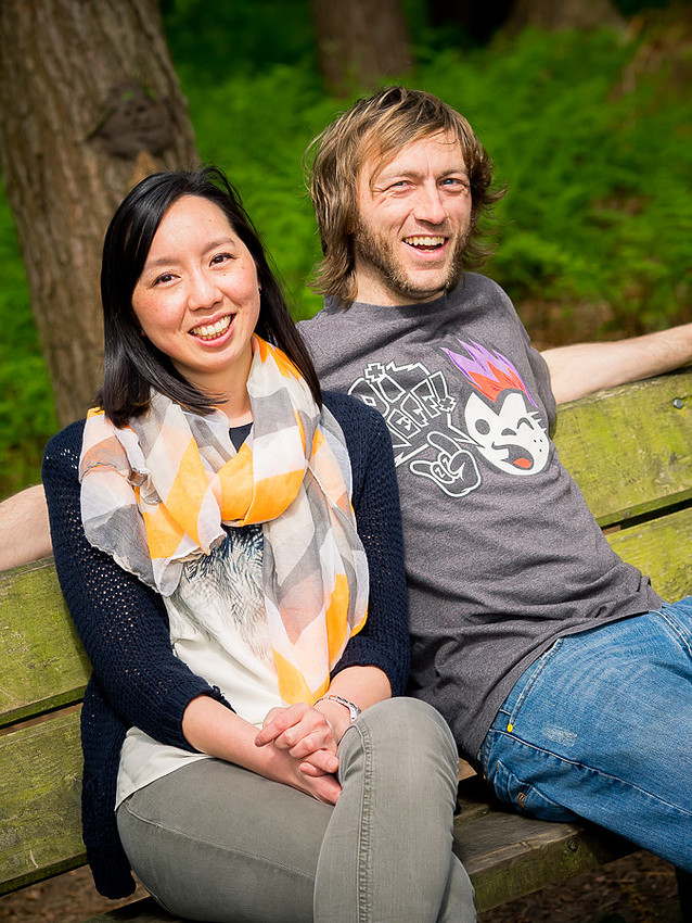 Photograph of Lisa & Dan sitting on a bench in Delamere Forest. Celynnen Photography. Pre Wedding Shoot. Dan & Lisa