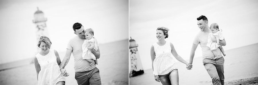 couple and their baby enjoying a walk on the beach during their portrait session with Celynnen Photography before their September wedding at the degawnwy quay